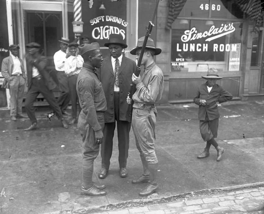 A confrontation takes place between a black WWI veteran and a white militiaman during the Chicago Race Riot of 1919.